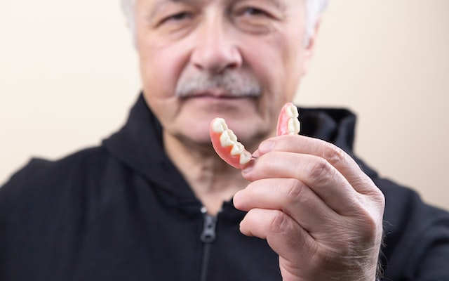 man holding denture image